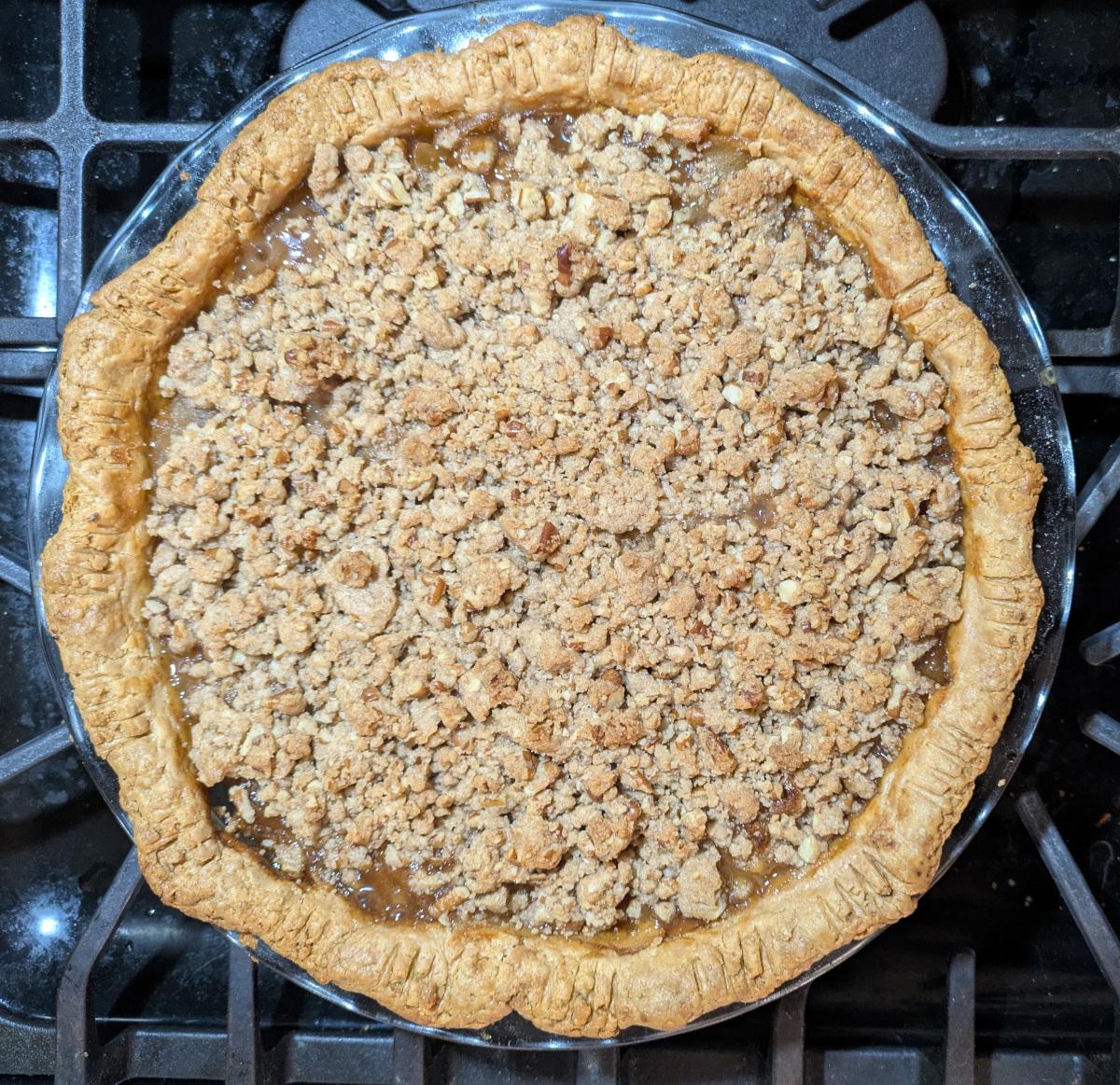 A baked apple pie with streusel topping viewed from above.