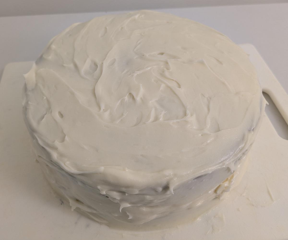 A round cake covered in white frosting.