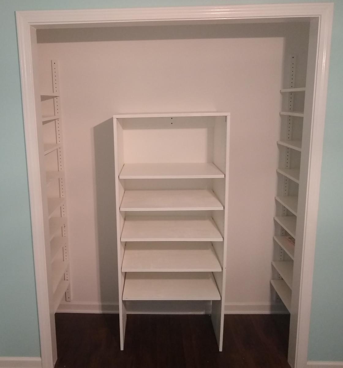 A closet with 9 adjustable shelves on each side and 5 adjustable shelves in the middle.