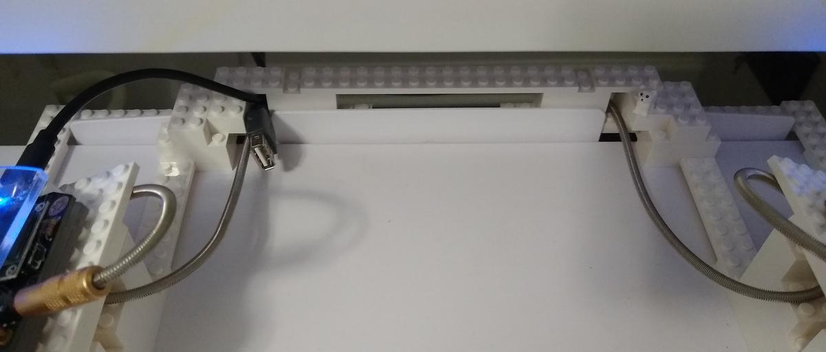 The current connector between the stand's two sides fits nicely over a plastic piece at the back of my keyboard tray and holds the cables in place as well.