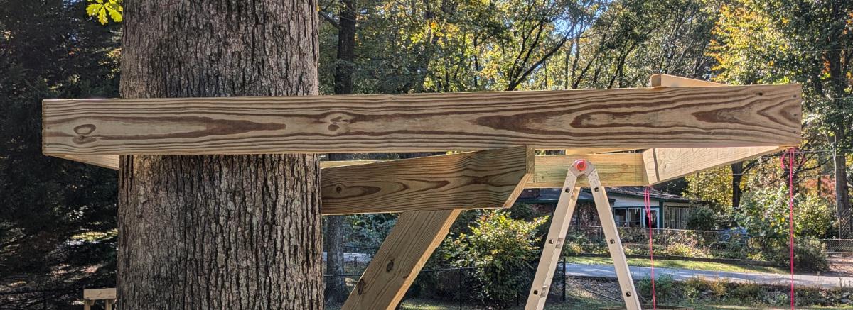 The square joist frame from a different angle, showing how it wraps around the tree in one corner.