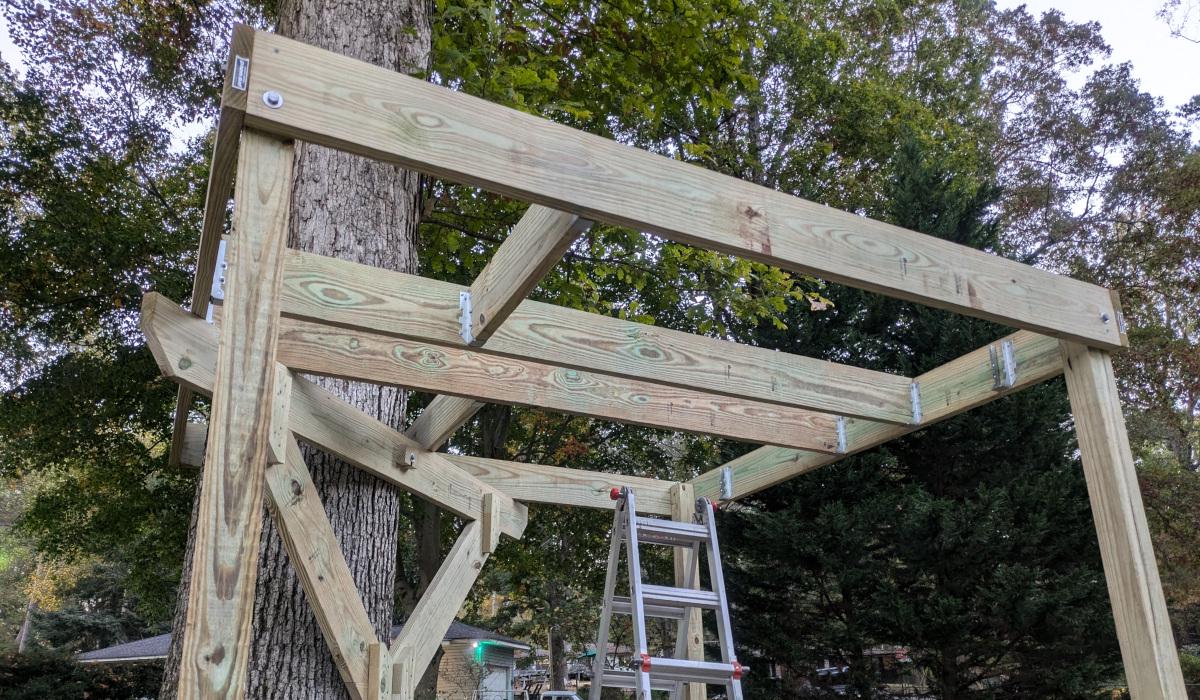 The joist frame attached to posts in three corners, with two horizontal joists and the two headers in place.